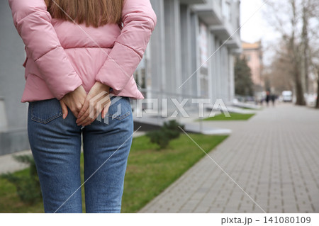 Woman suffering from hemorrhoid pain outdoors, closeup Woman suffering from hemorrhoid pain outdoors, closeup 141080109
