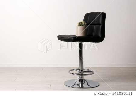 Chair with cactus near white wall, space for text. Hemorrhoids concept Chair with cactus near white wall, space for text. Hemorrhoids concept 141080111