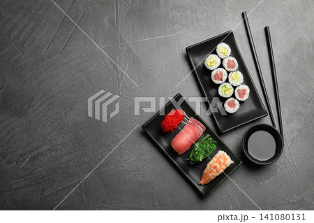 Set of delicious sushi and rolls on grey table, flat lay. Space for text 141080131