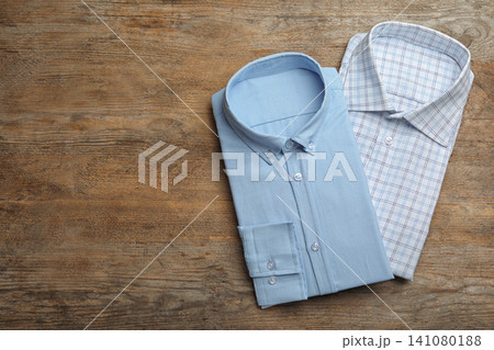 Stylish male shirts on wooden background, flat lay. Space for text 141080188