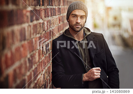 Man, portrait and winter fashion by brick wall downtown for aesthetic, modern and vacation for city culture. Male person, trendy urban outfit for streetwear style for creative career in New York 141080869