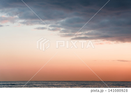 Tranquil Ocean Under Pink Sky With Thick Cloud Layers Tranquil Ocean Under Pink Sky With Thick Cloud Layers 141080928