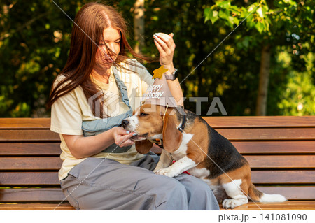 Woman Giving Birthday Treat to Beagle Dog Woman Giving Birthday Treat to Beagle Dog 141081090