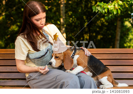 Woman Training Beagle with Birthday Treat Outdoors Woman Training Beagle with Birthday Treat Outdoors 141081093