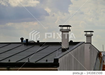 Rooftops and chimneys under cloudy sky Rooftops and chimneys under cloudy sky 141081500