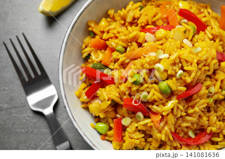Delicious rice pilaf with vegetables on grey table, closeup Delicious rice pilaf with vegetables on grey table, closeup 141081636