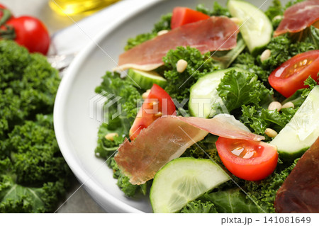 Delicious salad with kale leaves on table, closeup Delicious salad with kale leaves on table, closeup 141081649