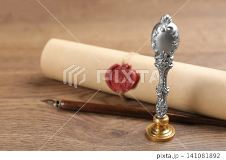 Notary's public pen and document with wax stamp on wooden table, closeup Notary's public pen and document with wax stamp on wooden table, closeup 141081892