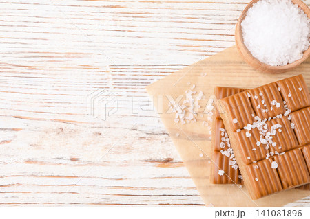 Salted caramel on white wooden table, top view. Space for text Salted caramel on white wooden table, top view. Space for text 141081896