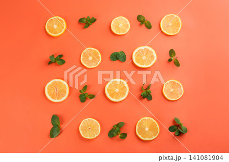 Lemonade layout with juicy lemon slices and mint on coral background, top view Lemonade layout with juicy lemon slices and mint on coral background, top view 141081904