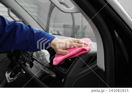 Car wash worker cleaning automobile interior, closeup 141081915