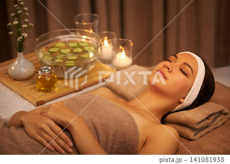 Sleeping, relax and woman at massage table in spa with cucumber for peace, calm or skincare. Body, salon and person resting for aromatherapy with candles for natural beauty or health with eyes closed Sleeping, relax and woman at massage table in spa with cucumber for peace, calm or skincare. Body, salon and person resting for aromatherapy with candles for natural beauty or health with eyes closed 141081938