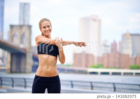 Woman, stretching and runner for fitness in city, mobility active and fit female person exercising in New York. Energy, flexibility for sports training and workout for athlete, cardio for endurance 141082075