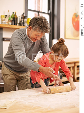 Cooking, rolling pin or grandfather with child in kitchen teaching a recipe for support or learning in home. Family, baking or girl with bowl, grandpa or senior man for dinner, supper or lunch meal Cooking, rolling pin or grandfather with child in kitchen teaching a recipe for support or learning in home. Family, baking or girl with bowl, grandpa or senior man for dinner, supper or lunch meal 141082214