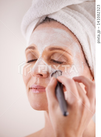 Hand, mature woman and mask with brush in studio for skincare or anti aging on self care, wellness and fresh skin. Closeup, female person and glow with smile or happy for facial and beauty for luxury Hand, mature woman and mask with brush in studio for skincare or anti aging on self care, wellness and fresh skin. Closeup, female person and glow with smile or happy for facial and beauty for luxury 141082323