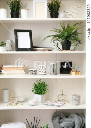 White shelving unit with plants and different decorative stuff White shelving unit with plants and different decorative stuff 141082399