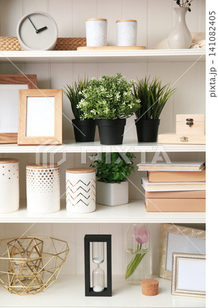 White shelving unit with plants and different decorative stuff White shelving unit with plants and different decorative stuff 141082405