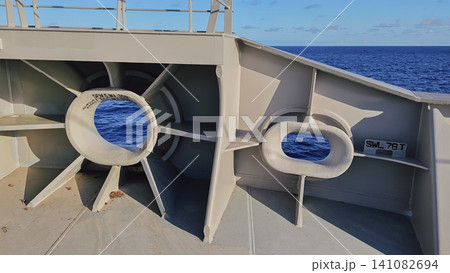 Horizontal close up shot of grey painted steel mooring chocks on a vessel deck with blue open sea water visible through the round safe working load openings Horizontal close up shot of grey painted steel mooring chocks on a vessel deck with blue open sea water visible through the round safe working load openings 141082694
