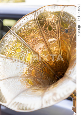 Close-up of an intricate brass gramophone horn with floral embossed patterns. Vertical Close-up of an intricate brass gramophone horn with floral embossed patterns. Vertical 141083091