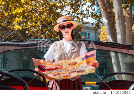 Female tourist reading a map on a red sightseeing bus Female tourist reading a map on a red sightseeing bus 141083096