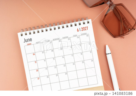 2027 June desk calendar with brown sunglasses. Directly above. Calendar and reminder concept. 2027 June desk calendar with brown sunglasses. Directly above. Calendar and reminder concept. 141083186