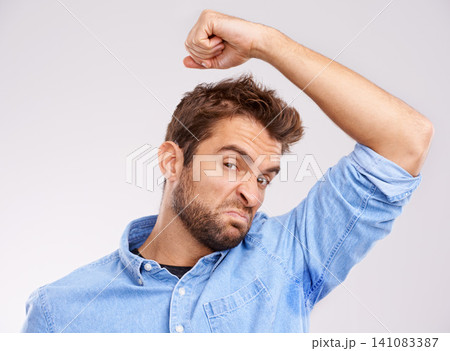 Man, smell armpit and bad hygiene, body odor with stink and sweat stain isolated on white background. Hyperhidrosis, poor hygiene and dirty, foul or negative with disgust for underarm in studio Man, smell armpit and bad hygiene, body odor with stink and sweat stain isolated on white background. Hyperhidrosis, poor hygiene and dirty, foul or negative with disgust for underarm in studio 141083387