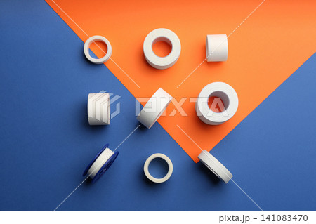 Sticking plaster rolls on color background, flat lay Sticking plaster rolls on color background, flat lay 141083470