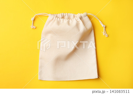 Cotton eco bag on yellow background, top view Cotton eco bag on yellow background, top view 141083511
