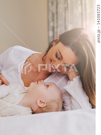 Mother, playful and care with baby on bed for bonding, love and relaxing together in bedroom. Lens flare, happy woman and daughter for childhood development, support and nursery in apartment Mother, playful and care with baby on bed for bonding, love and relaxing together in bedroom. Lens flare, happy woman and daughter for childhood development, support and nursery in apartment 141083723
