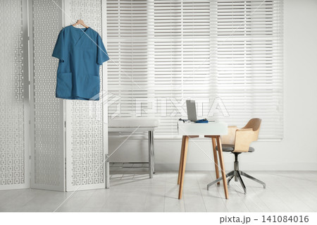 Doctor's office interior with desk and examination couch Doctor's office interior with desk and examination couch 141084016