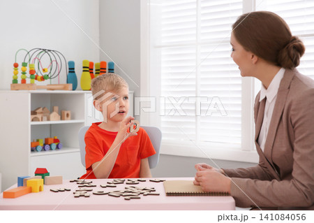 Speech therapist working with little boy in office Speech therapist working with little boy in office 141084056