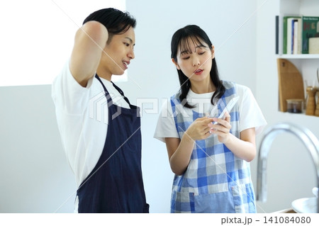 キッチン スマホでレシピを考える男女のイメージ キッチン スマホでレシピを考える男女のイメージ 141084080