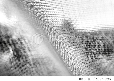 a close-up, black and white view of a textured fabric. a close-up, black and white view of a textured fabric. 141084265