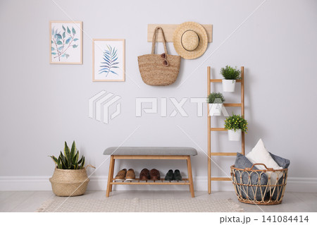 Beautiful plants and comfortable bench near white wall at home. Idea for interior design Beautiful plants and comfortable bench near white wall at home. Idea for interior design 141084414