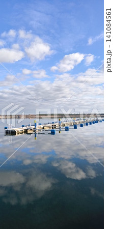Boat dock, sailboats, blue sky, blue lake, sun, clouds, yacht marina Boat dock, sailboats, blue sky, blue lake, sun, clouds, yacht marina 141084561