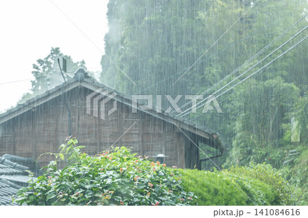 田舎の古民家に激しい雨が打ち付けている 田舎の古民家に激しい雨が打ち付けている 141084616