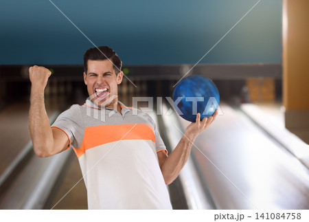 Excited man with ball in bowling club Excited man with ball in bowling club 141084758
