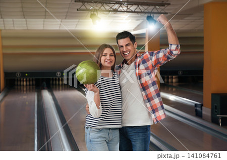 Happy couple with ball in bowling club Happy couple with ball in bowling club 141084761