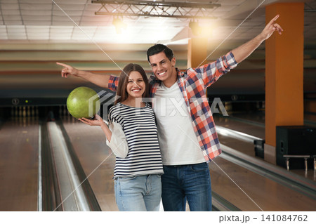 Happy couple with ball in bowling club Happy couple with ball in bowling club 141084762