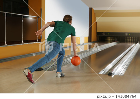 Young man throwing ball in bowling club Young man throwing ball in bowling club 141084764