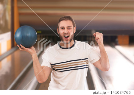 Young man with ball in bowling club Young man with ball in bowling club 141084766