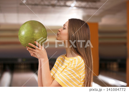 Young woman with ball in bowling club Young woman with ball in bowling club 141084772
