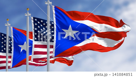 Flags of Puerto Rico waving with the United States flags on a clear day Flags of Puerto Rico waving with the United States flags on a clear day 141084851