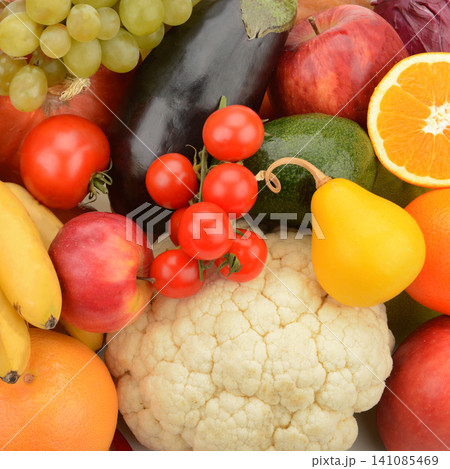 A vibrant assortment of ripe fruits and crisp vegetables forms a dense, colorful background pattern. A vibrant assortment of ripe fruits and crisp vegetables forms a dense, colorful background pattern. 141085469