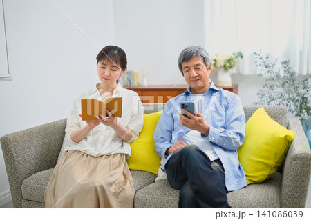 ソファーに座ってリラックスして過ごすシニアの夫婦 ソファーに座ってリラックスして過ごすシニアの夫婦 141086039