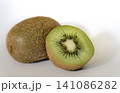 Whole kiwi fruit next to a fresh cut half on white background. 141086282
