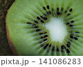 Macro close-up of a fresh kiwi fruit cross section showing seeds and pulp. 141086283