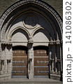 Ancient Wooden Doors of a Gothic Church with Stone Arch 141086302