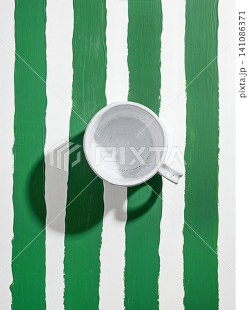 empty white ceramic coffee cup on striped table top empty white ceramic coffee cup on striped table top 141086371