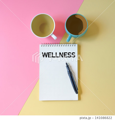 Text WELLNESS write on notebook and pen,health concept. Text WELLNESS write on notebook and pen,health concept. 141086822